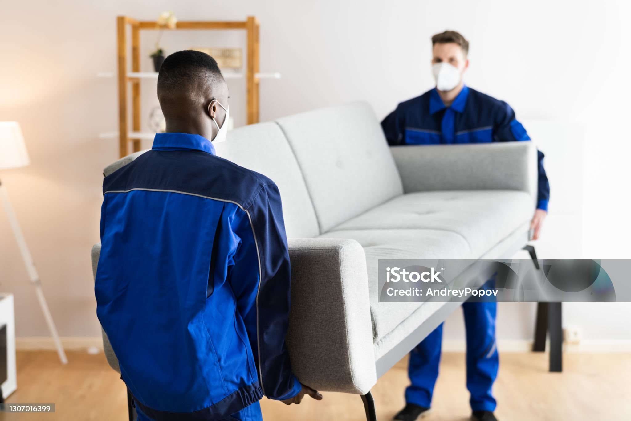 Furniture Movers Relocating House In Covid Face Mask